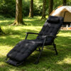 Black zero gravity recliner chair with a thick padded cushion and adjustable headrest set up on a grassy lawn near a camping tent